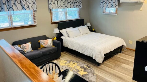 A bedroom with a bed, a sofa, a desk, and a ceiling fan. - OBX gem, private studio, couple's nest!  (Kill Devil Hills)