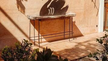 A swan silhouette on a wall, a stone bench, and potted plants.