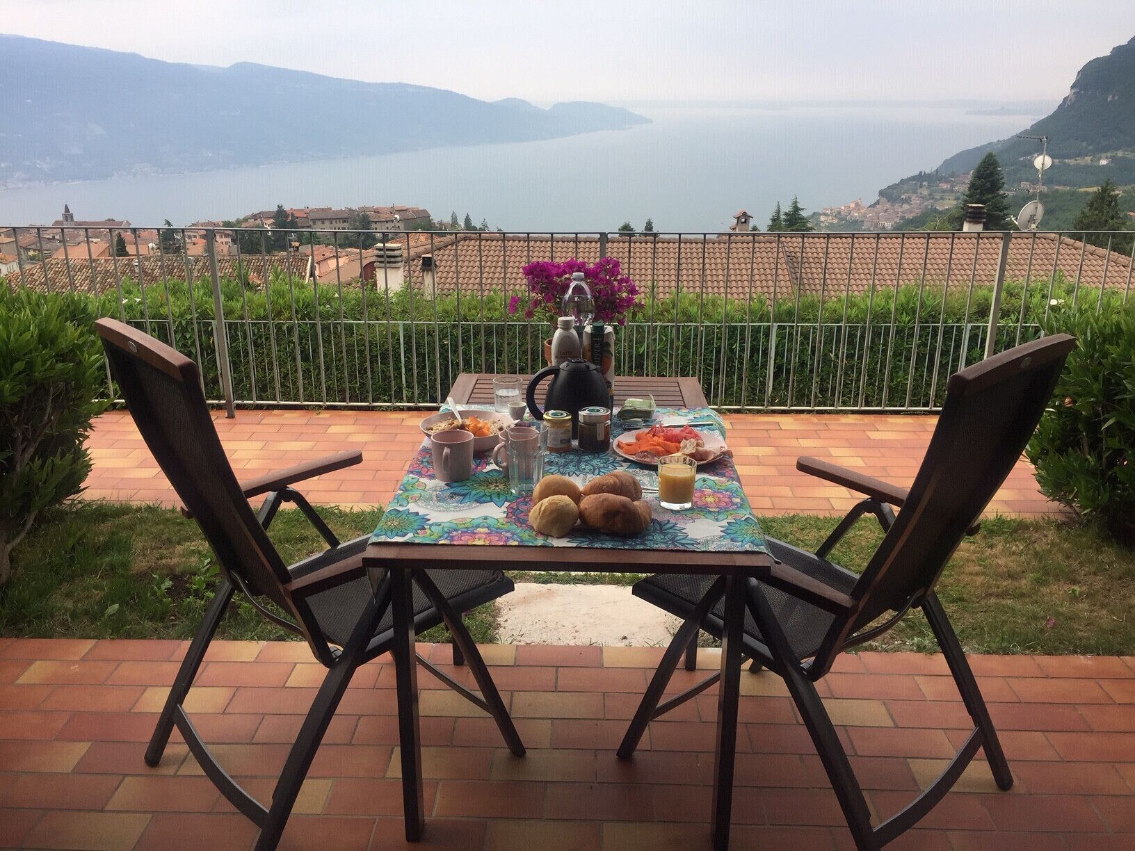 Une table dressée à l’extérieur, avec vue sur un lac et des montagnes.