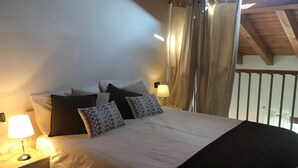 A neatly made bed with a white comforter and two patterned pillows, a bedside lamp, and a nightstand with a drawer. - Francesco by Theater Home, with pool and marvellous lake view (Tignale)