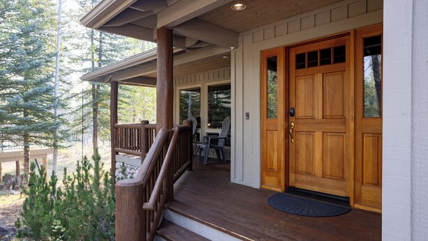 A wooden front porch with a set of stairs leading to a door, surrounded by trees. - ACER04 - Spacious Home, Hot Tub, Fireplace, Ping Pong, Foosball (Sunriver)