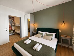 A modern hotel room with a bed, two bedside tables, a green headboard, and a painting on the wall. - Elisa by Theater Home, with big terrace and marvellous lake view (Tignale)