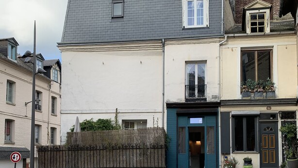 A cobblestone street with a building featuring a blue door and a small balcony with potted plants. - Duplex apartment (two people) (Dieppe)