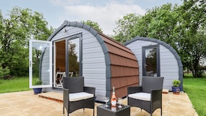 Two mobile homes with a patio area featuring wicker furniture and a bottle of wine. - Meadow Lodge @ Berrys Place Farm (Gloucester)