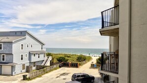 Un bâtiment situé sur la côte, doté d’un balcon donnant sur la plage et l’océan.