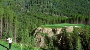 Ein Golfplatz mit Bergpanorama, eine Person in weißem Hemd und dunkler Hose, die bereit ist, einen Golfball zu schlagen, und ein klarer Himmel.