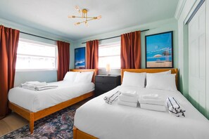 A hotel room with two beds, a nightstand, a lamp, a painting, and a patterned rug. - 137 · ☀Pool✔ Kitchen✔ Beach✔ Self Checkin✔ Free Parking✔ (Clearwater)