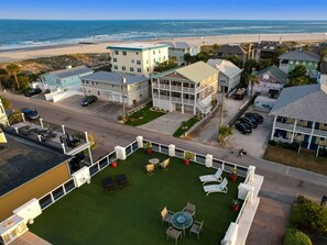 Un h ôtel situé sur la côte, composé de plusieurs bâtiments, doté d’un parking et d’une pelouse verdoyante avec des espaces de détente en plein air.