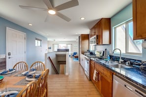 Enjoy meals in this stylish kitchen and dining area, featuring a wooden table for four and a modern design.