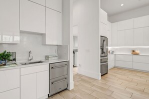 Enjoy cooking in this well-lit kitchen with sleek cabinetry and stainless steel appliances.