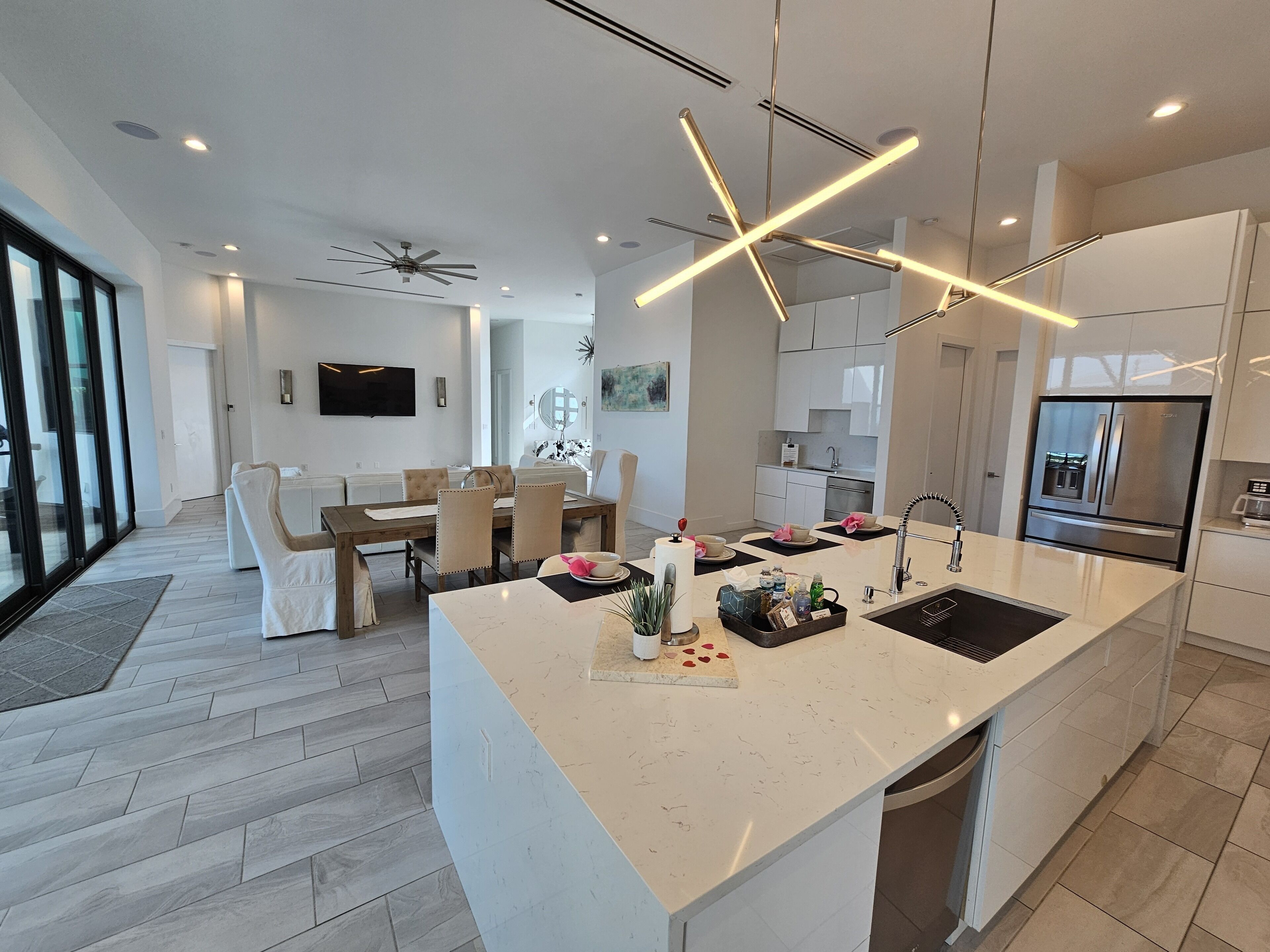 A modern kitchen with a central island, built-in appliances, and a dining area with a large window.