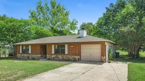 A single-story house with a garage, a front porch, and a well-maintained lawn. - Cedar Hideaway! (Crystal River)