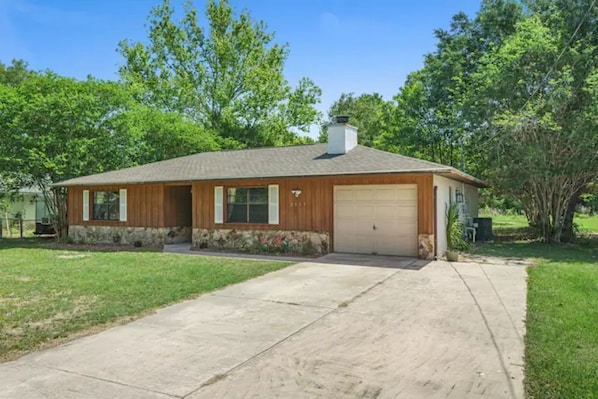 A single-story house with a garage, a front porch, and a well-maintained lawn. - Cedar Hideaway! (Crystal River)