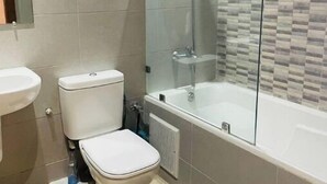 Ein Badezimmer mit Toilette, Waschbecken und Badewanne.