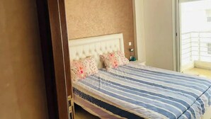 Ein Schlafzimmer mit Bett, Kopfteil und Tür.