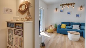 A room with a white cabinet displaying various decorative items, a blue sofa with yellow cushions, and a hanging light fixture. - Cottage only 20 meters from the beach (Premantura)