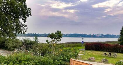 Newly built wooden house "Remise am Fährhaus" with unique architecture directly on the Schlei with jetty and bathing area for your well-deserved vacation in an absolute feel-good atmosphere, with a huge garden area and old trees