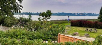 Newly built wooden house "Remise am Fährhaus" with unique architecture directly on the Schlei with jetty and bathing area for your well-deserved vacation in an absolute feel-good atmosphere, with a huge garden area and old trees