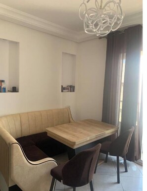 Enjoy meals in this stylish dining area with a light-colored bench, dark chairs, and a wooden dining table.