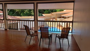Un balcón con vista a una piscina y edificios circundantes.