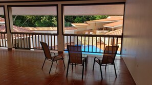 Un balcon donnant sur une piscine et les bâtiments environnants.