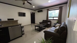 Una sala de estar moderna con un sofá, una mesa de centro y un ventilador de techo.