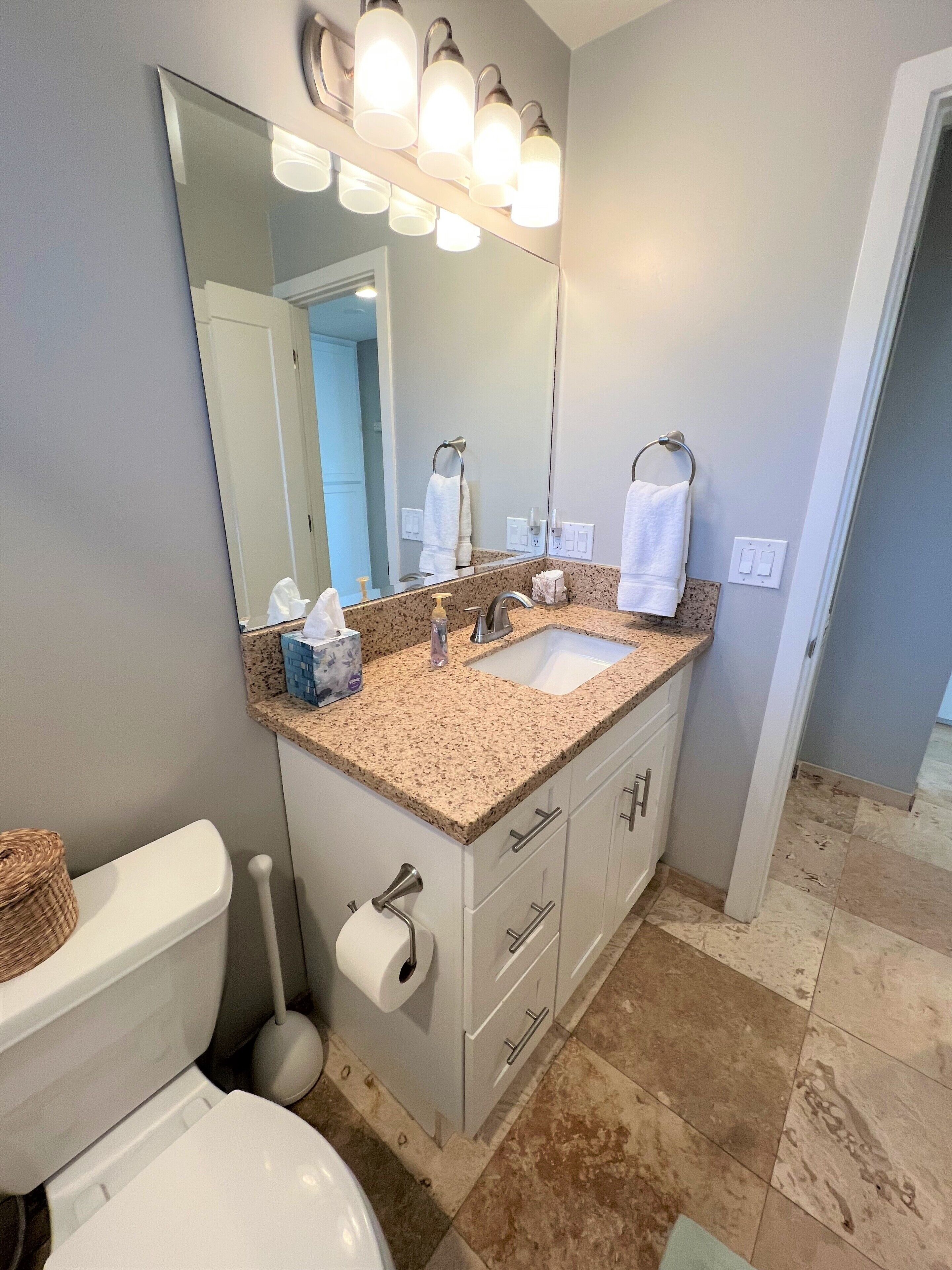 A bathroom with a sink, mirror, and toilet.