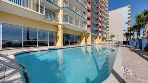 A hotel with a swimming pool, balconies, and a view of the ocean. - Oceanfront Luxury 4BR Condo w/ Large Balcony & Pool (Myrtle Beach)
