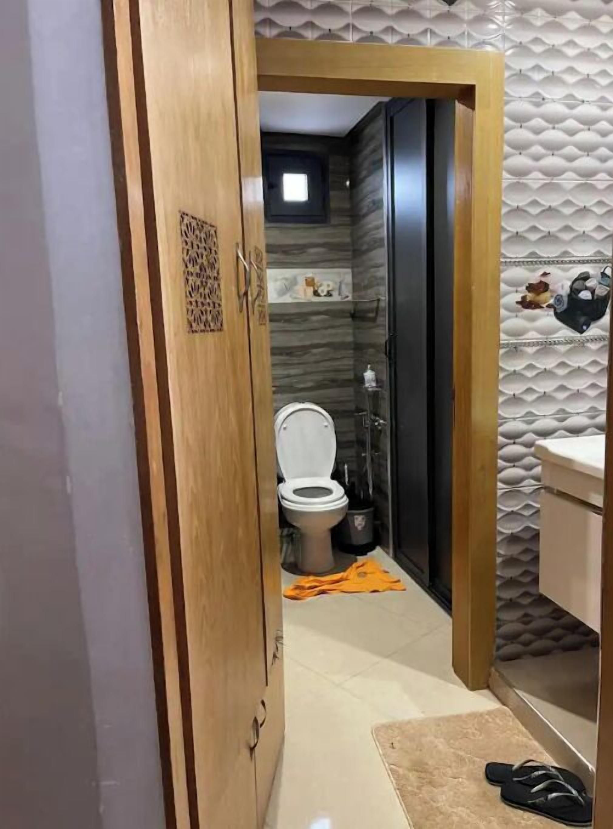 A bathroom with a toilet, a shower, and a sink.