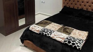 Un dormitorio con cama, armario y espejo.
