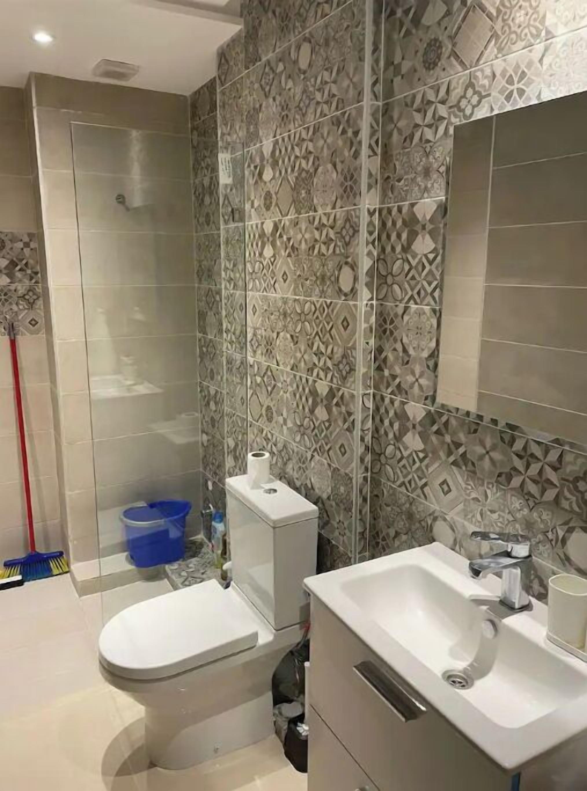 Une salle de bain comprenant des toilettes, un lavabo et un espace douche.