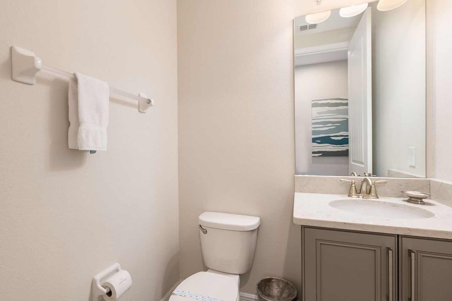 Une salle de bain avec des toilettes, un lavabo et un miroir.