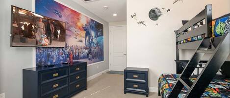 A bedroom with a bunk bed, a dresser, a mirror, and Star Wars-themed decorations.