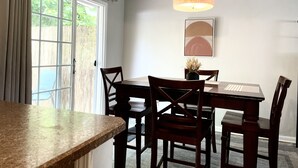 Zona pranzo con tavolo, sedie e lampadario.