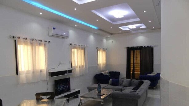 A modern living room with a flat-screen TV, a sofa, and a coffee table.