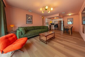 Relax in a comfortable seating area with a green sofa and vibrant armchair, perfect for unwinding.
