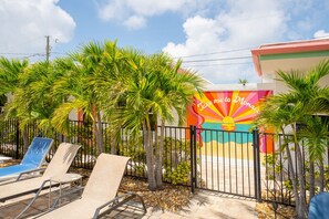Relax by the pool in a tropical oasis with lounge chairs and a small pool.