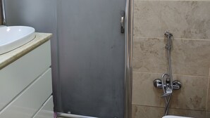 Ein Badezimmer mit Duschkabine, Waschbecken und Toilette.