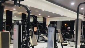 A gym with various exercise machines, benches, and a mirrored wall. - New furnished apartment with on-site parking  (Site archéologique de Carthage)