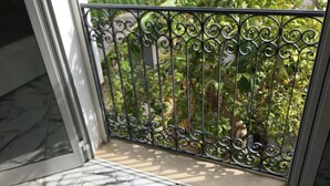 A balcony with a metal railing and a view of greenery. - New furnished apartment with on-site parking  (Site archéologique de Carthage)