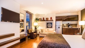 A modern hotel room with a large bed, a flat-screen TV, a sofa, a dining area, and a kitchen. - Hotel Cabrera Imperial By Key 33 (Bogotá)