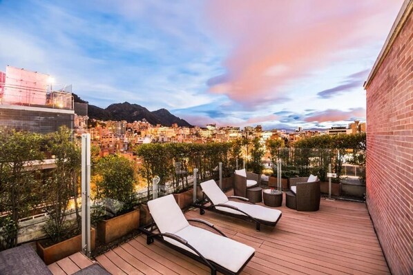 A rooftop terrace with lounge chairs, planters, and a cityscape view. - Hotel Cabrera Imperial By Key 33 (Bogotá)