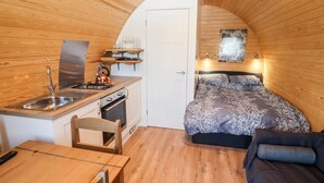 A compact room with a kitchenette, a bed, and a seating area. - Gander Pod (Worcester)