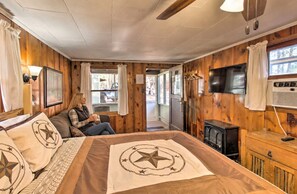 A cozy room with a bed, a television, and a fireplace.