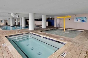 An indoor swimming pool with multiple lanes, a diving area, and a water slide. - Oceanfront Myrtle Beach Condo: Beach Views & Pool! (Myrtle Beach)