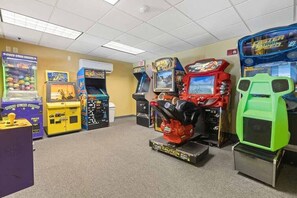 A room with multiple arcade games, including a claw machine and racing games. - Oceanfront Myrtle Beach Condo: Beach Views & Pool! (Myrtle Beach)