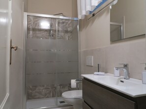Een douche, een haardroger, een bidet, handdoeken