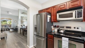 Una cocina moderna con electrodomésticos de acero inoxidable, armarios de madera y un comedor con vistas.