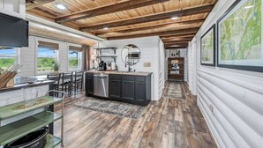 Una cucina moderna con travi in legno, un'isola centrale e vista sull'esterno.