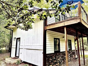 A white wooden building with a porch and a small window. - River Rock Cabin - Private Escape - ON the Etowah River! Private decks/firepits! (Dahlonega)